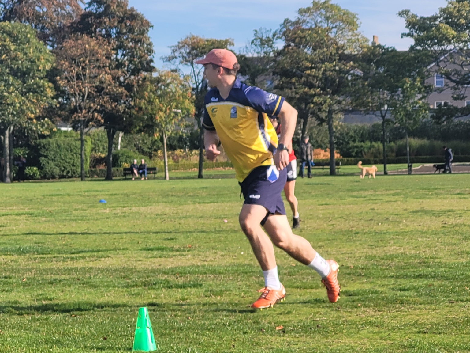Referee in yellow kit running across a Touch pitch